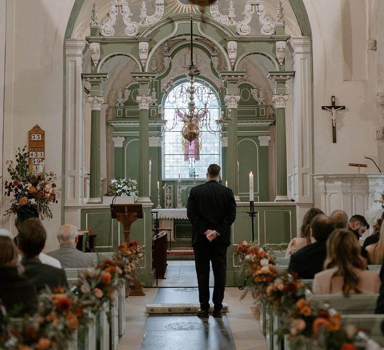 Groom awaits bride's arrival at church wedding ceremony