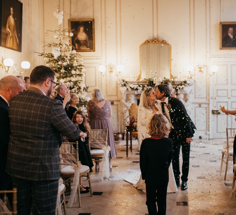 Bride & groom kiss as confetti cannon goes off around them