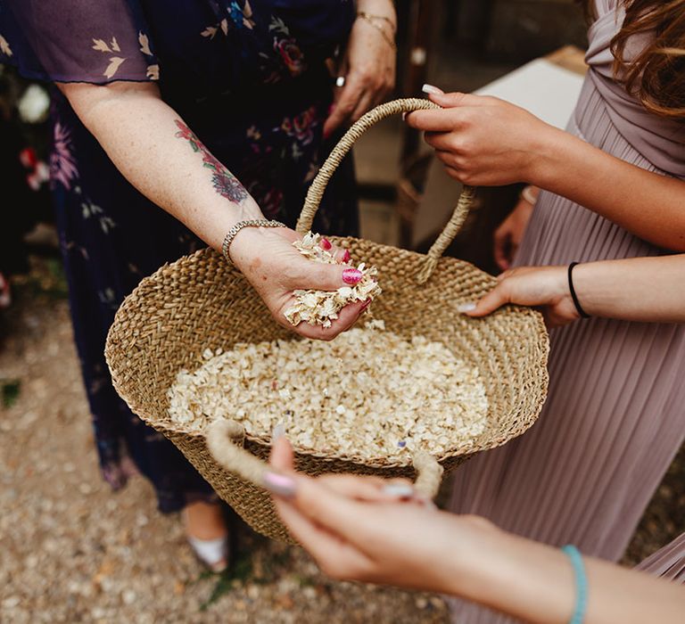 Bridesmaids hold wicker basket of confetti 