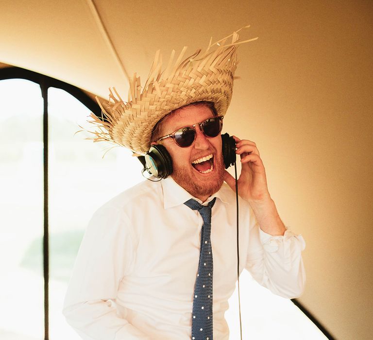 DJ in straw hat plays tunes for the wedding party