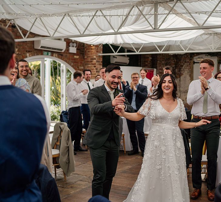 Bride & groom surrounded by wedding guests at Northbrook Park during reception 