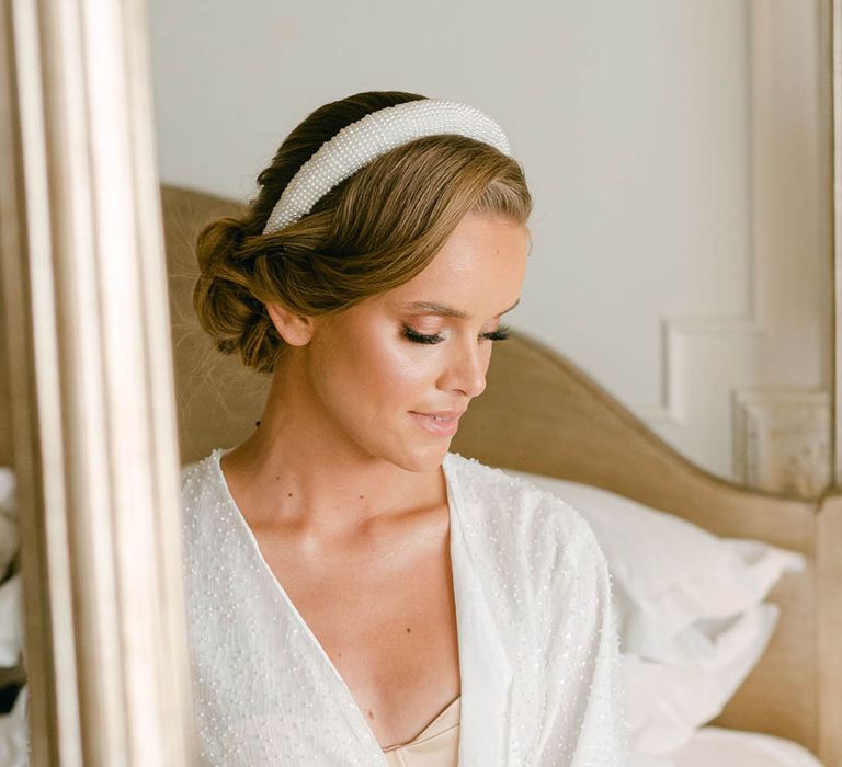 Bride wearing a sparkly robe and neutral wedding lingerie with a beaded headband accessory 