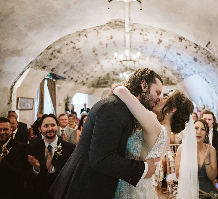 Bride & groom kiss at Neidpath Castle during their civil wedding ceremony as guests clap 