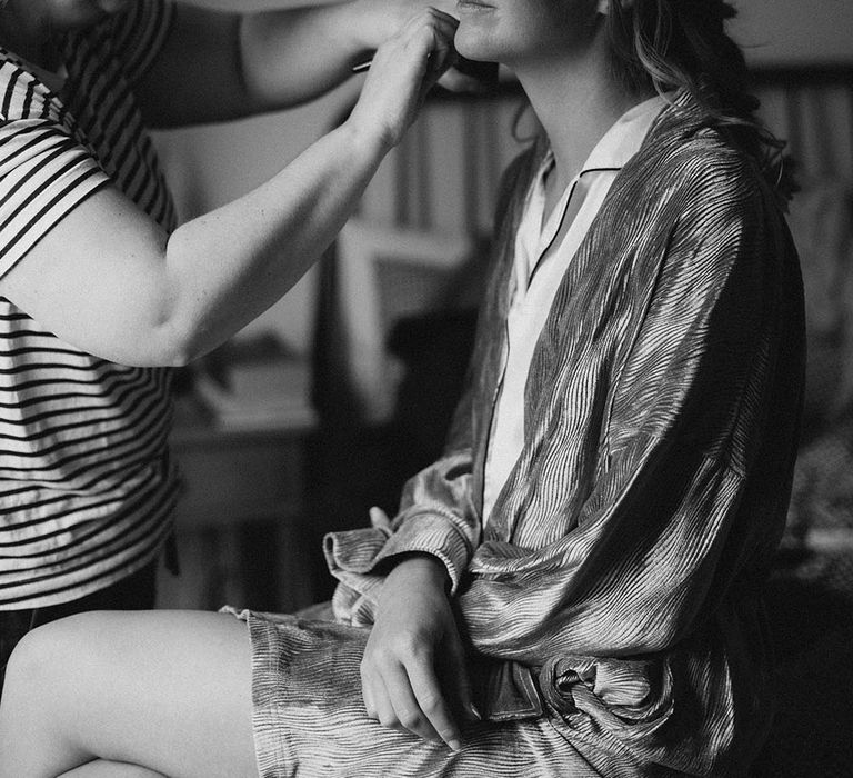 Bride has her makeup done on the morning of her wedding day at Tunnels Beach 