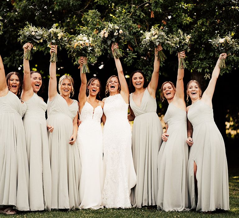 Two brides in lace fitted wedding dress with their bridesmaids in soft green bridesmaid dresses