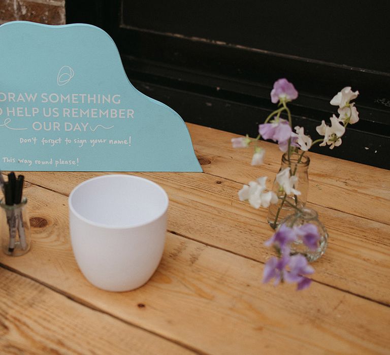 Alternative wedding guest book idea with pens for guests to draw on the mugs 