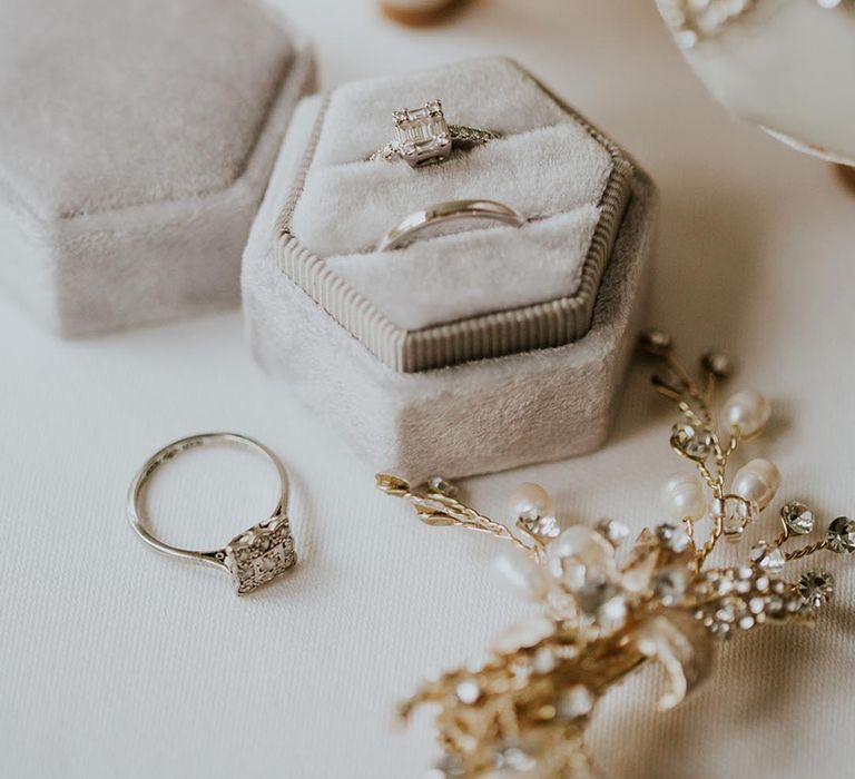 White velvet ring box with an emerald cut engagement ring and plain band 