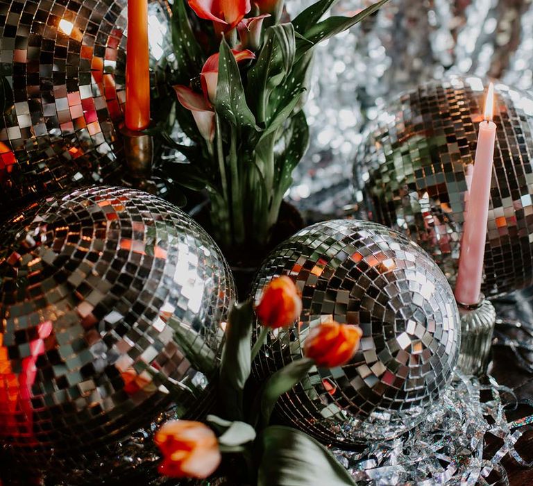 Sequin table cloth with disco balls and bright taper candles for wedding decor 