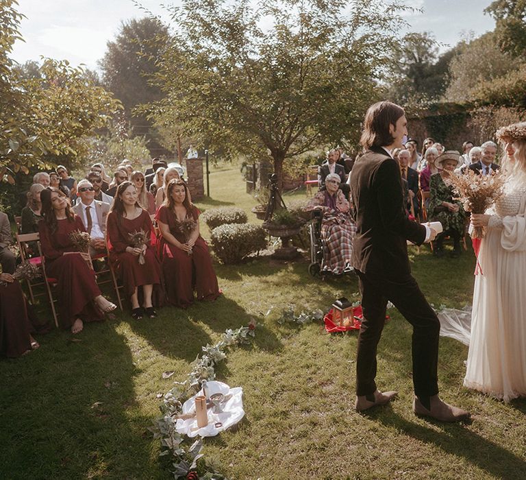 Bride & groom marry outdoors during Pagan wedding with boho and festival feel 