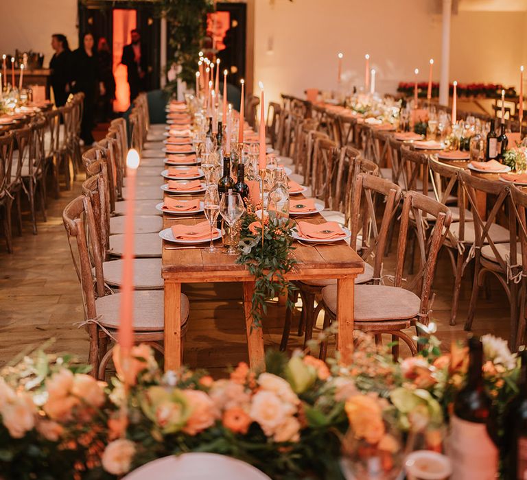 Silver and gold wedding streamer decorations, orange tapered candles, orange napkins, orange rose and foliage tablerunners and fairy lights 