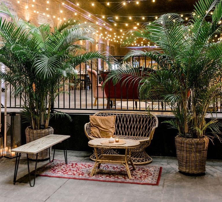 Lush green plants beside wicker furniture and Moroccan rugs 