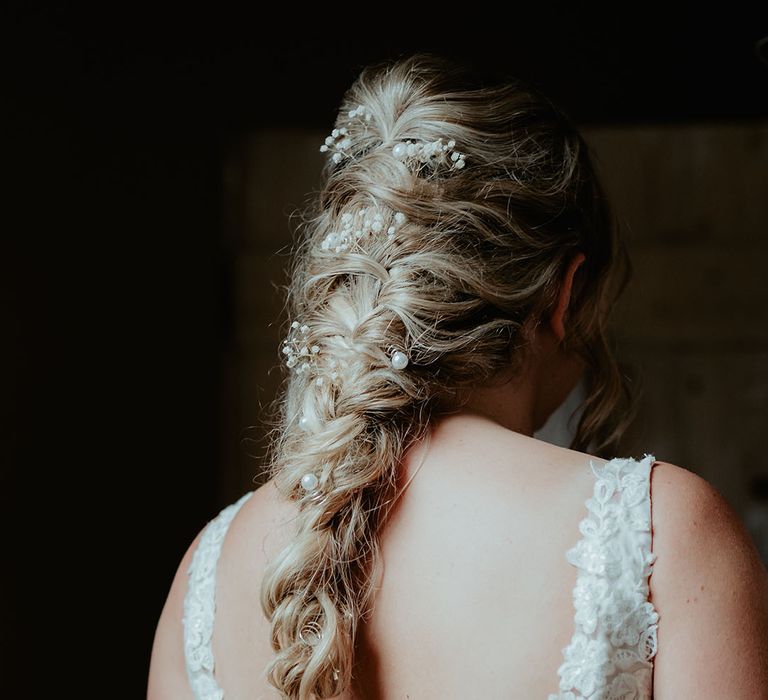 Bride wears fishtail braid complete with wildflower hair accessories 