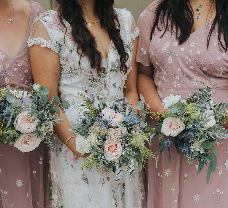 bridal party holding pastel pink and blue wedding bouquets 