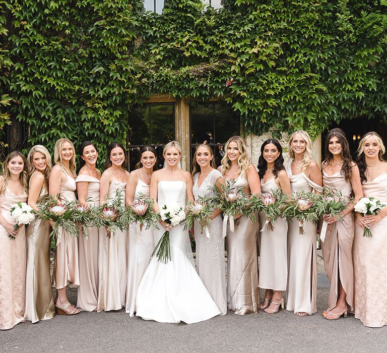 Bridesmaids in mismatched gold bridesmaid dresses with the bride for the traditional wedding 