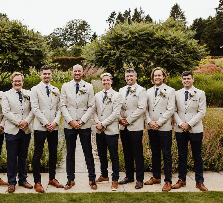 The groomsmen all in matching light grey suits with blue ties 