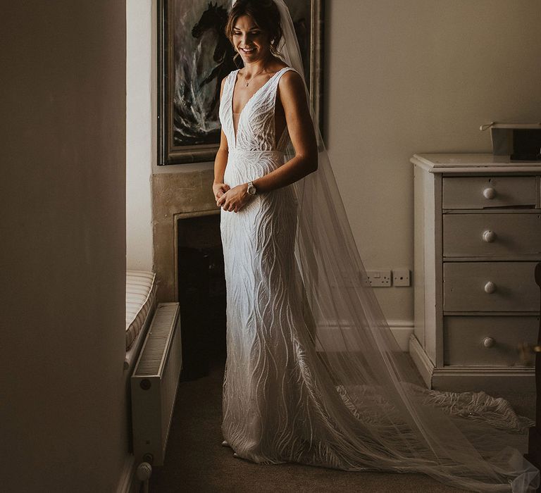 Bride in fitted beaded wedding dress by Made With Love with wedding veil to complete the look 