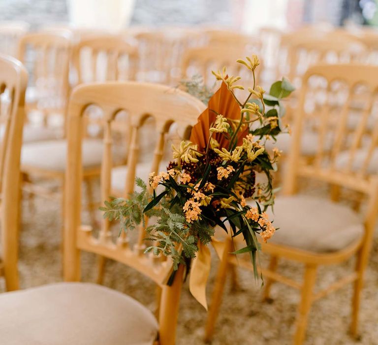 Wedding aisle flower inspiration at Broadfield Court - floral arrangement with yellow tall kangaroo paws, orange osmanthus flowers, foliage and dried flowers 