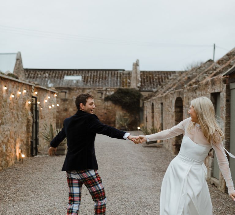 The bride and groom take cute couple portraits together as they dance 