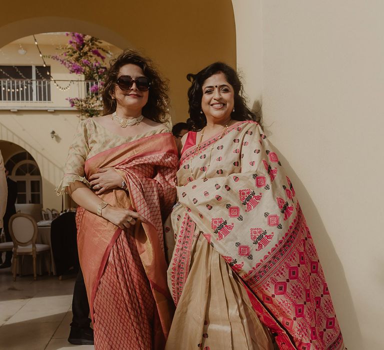 Multicultural wedding with wedding guests in gold and red Lehenga's