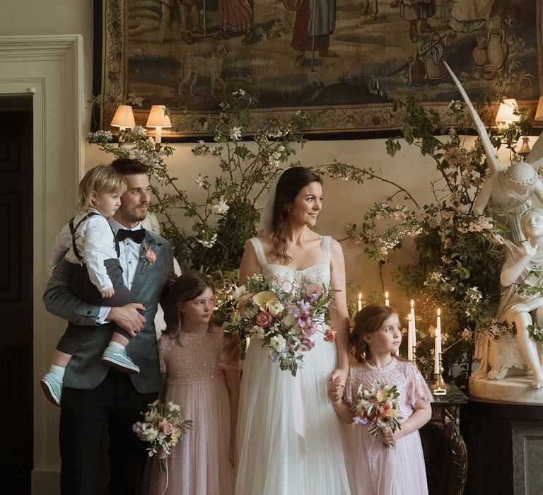 The bride and groom stand with their children at their wedding ceremony 