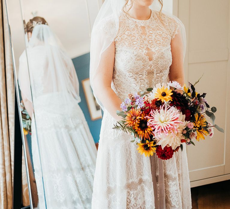 Boho style wedding dress with delicate lace detailing worn by bride with elegant updo 