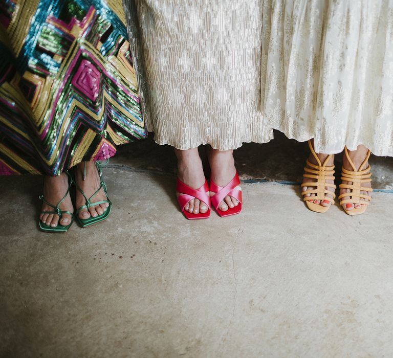 Bridesmaids in mismatched shoes featuring emerald green strappy heels, pink satin mules, mustard gladiator heeled sandals and orange lace up heels