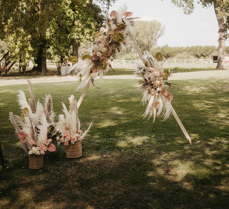 wooden frame altar decorated with pampas grass floral arrangements 