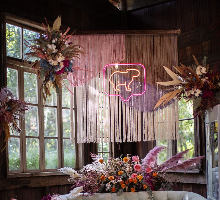 Capybara neon sign and eclectic wedding decor at Brazilian wedding in villa wedding venue 