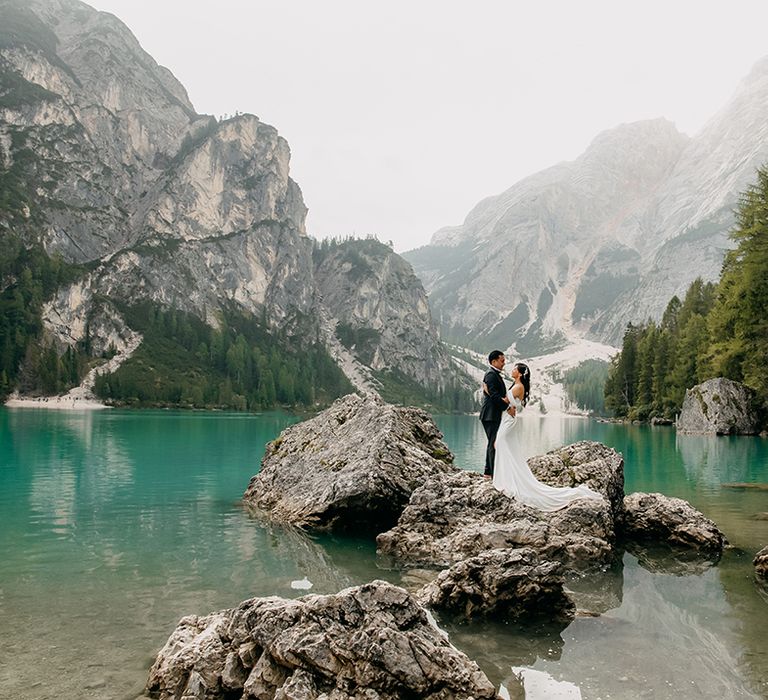 The bride and groom pose on rocks together for epic wedding photos 