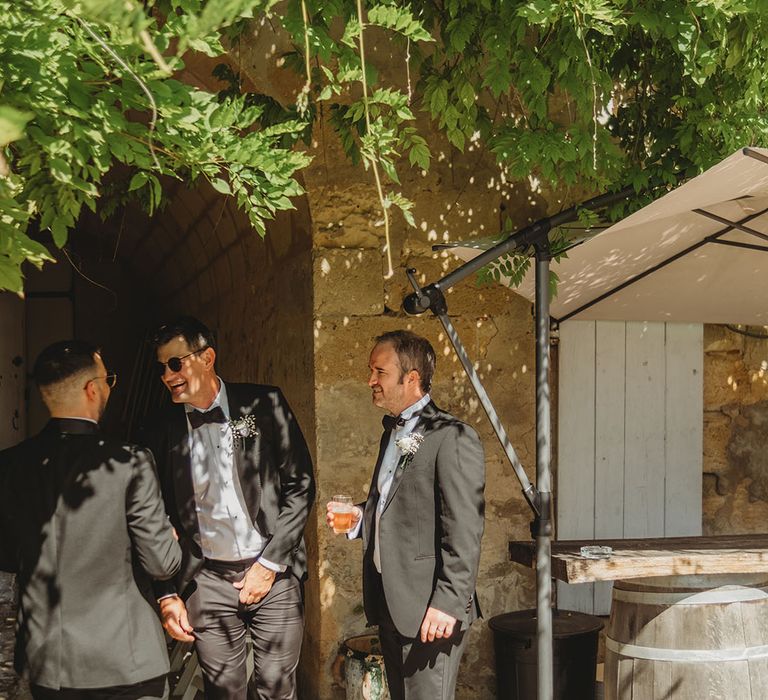 Groom and groomsmen wearing black tuxedos at black tie wedding 