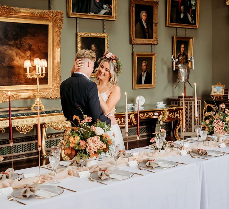 The bride and groom at autumnal wedding at Somerley House with themed flowers and candles 