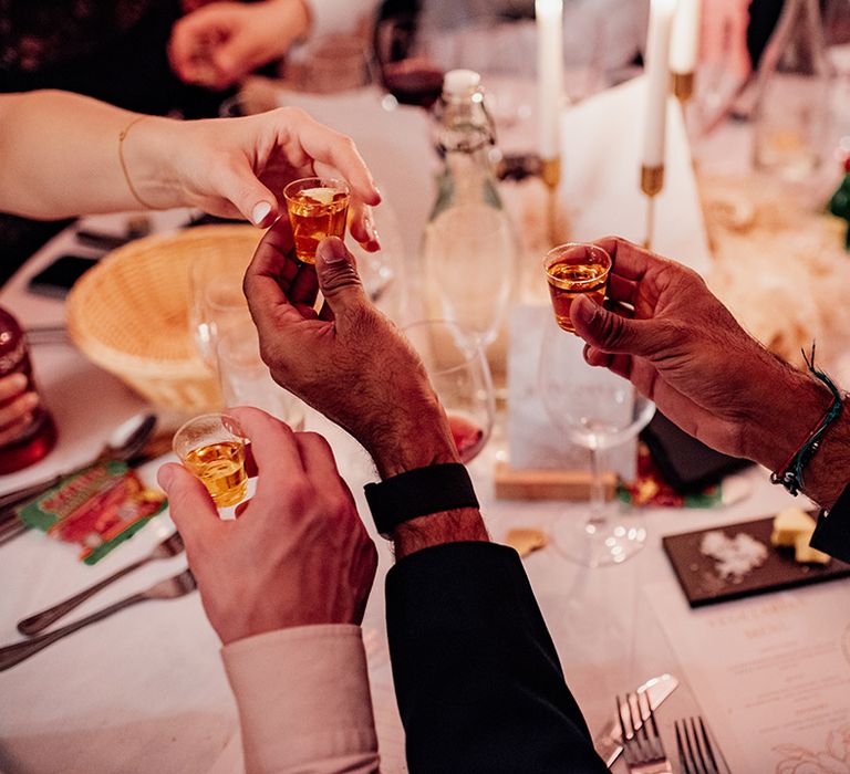 Wedding guests doing shots together at the wedding breakfast 