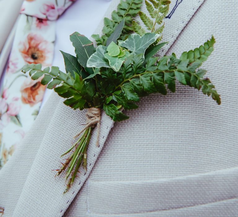 Foliage buttonhole groom's accessory with floral tie