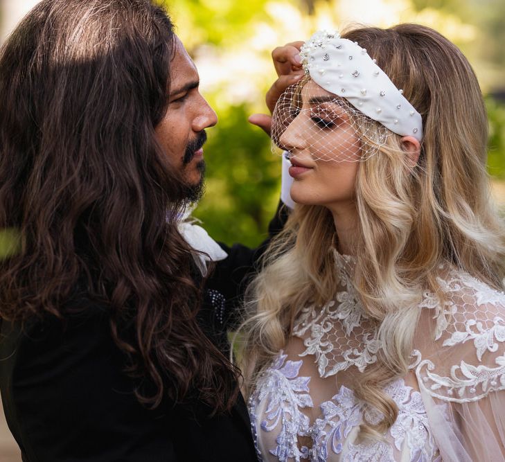 Wedding portrait of groom with long hair and bride in wedding headband 