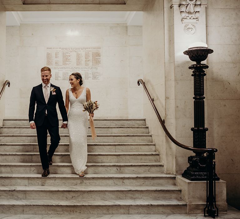 Bride and groom walking down the steps at Old Marylebone Town Hal