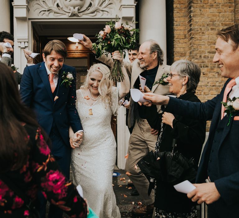 Bride & groom leaving registry office with wedding party 