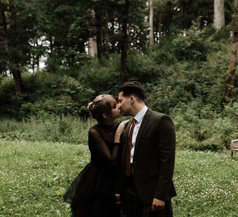 Bride & groom kiss in the woodlands during Scottish elopement