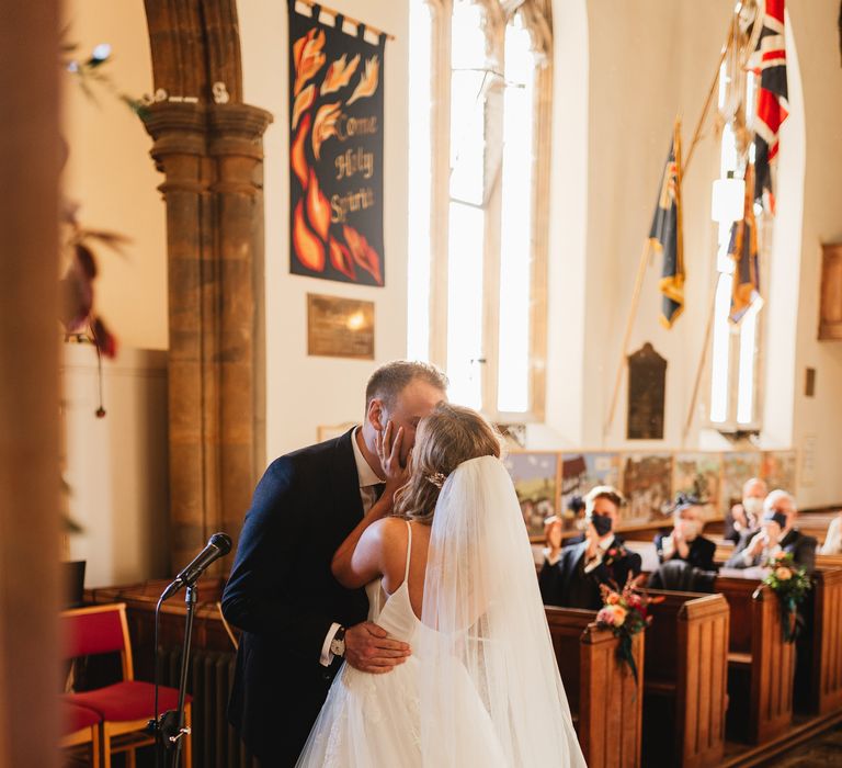 Bride & groom kiss during wedding ceremony