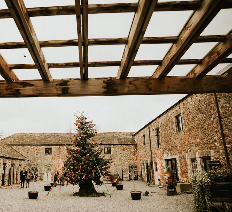 Christmas tree decorated in green and red decorations int he courtyard at Anran wedding venue 