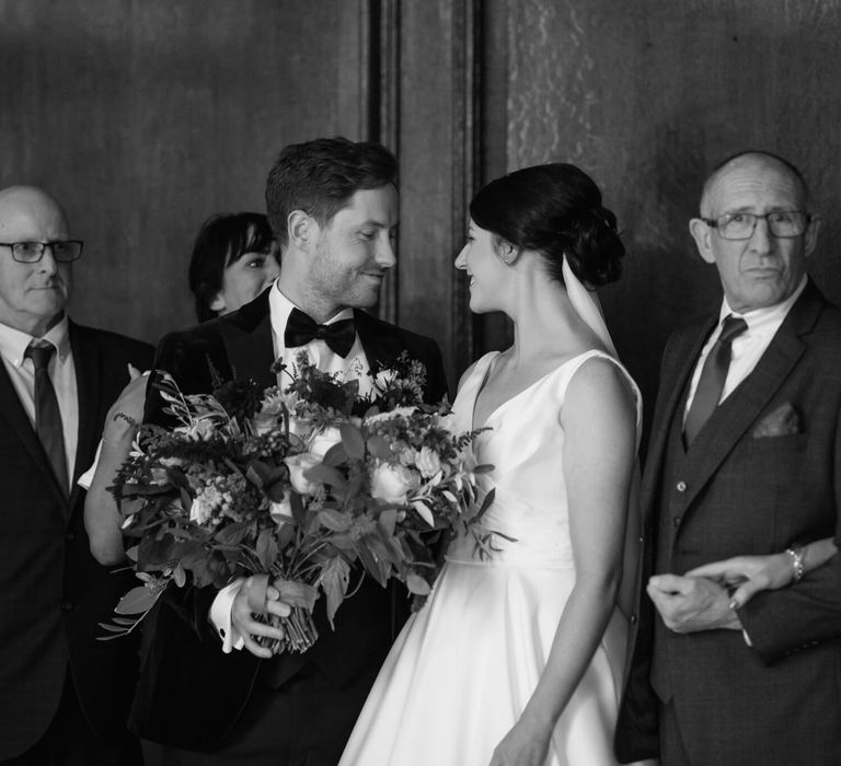 Black and white photography of bride and groom looking into one another's eyes