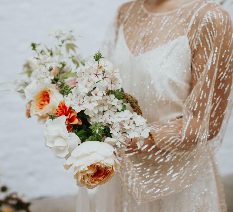 White, orange and blush flowers complimented the white and gold wedding theme