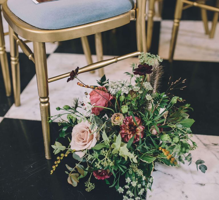 Gold wedding seats with bright pink rose flowers 