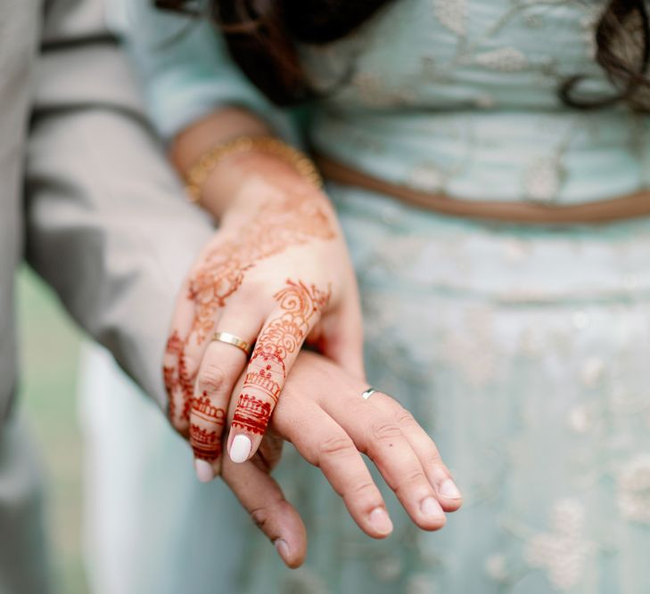 Muslim bride with Henna holding her her husband's hand