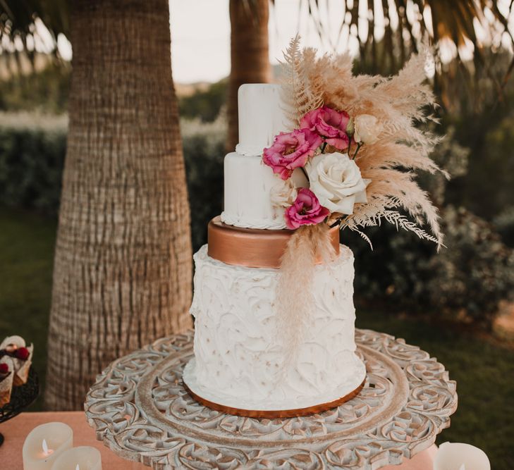 Four tier wedding cake with ruffle and gold laters and dried flower decor 