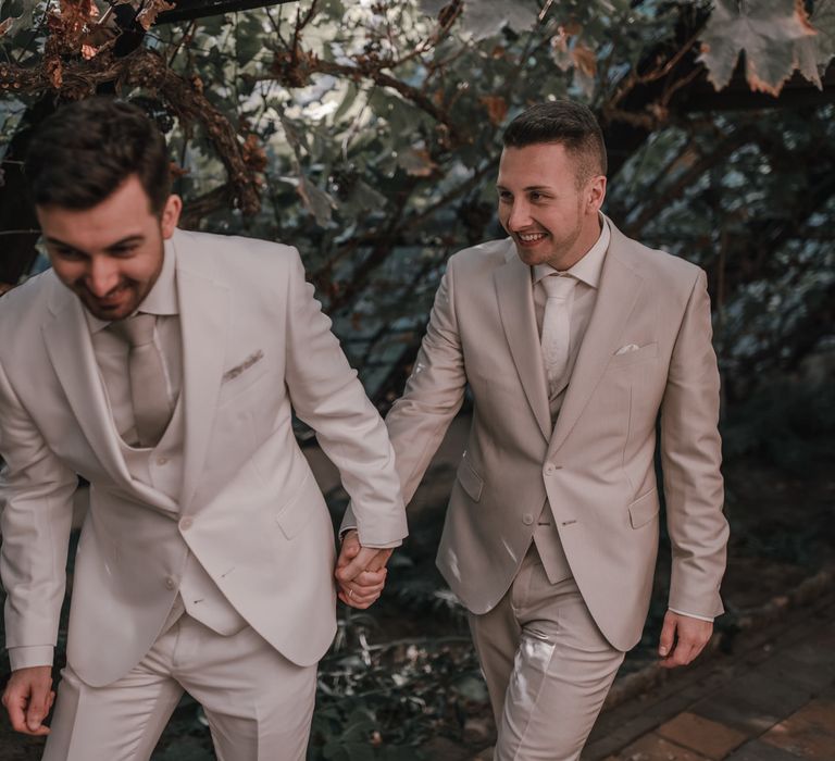 Groom in light grey wedding suit for gay wedding