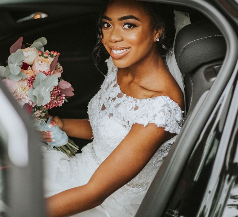 Beautiful bride in the wedding car in a lace wedding dress with high neck 