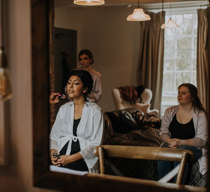 An Asian bride looks in the mirror as she gets ready for her wedding.