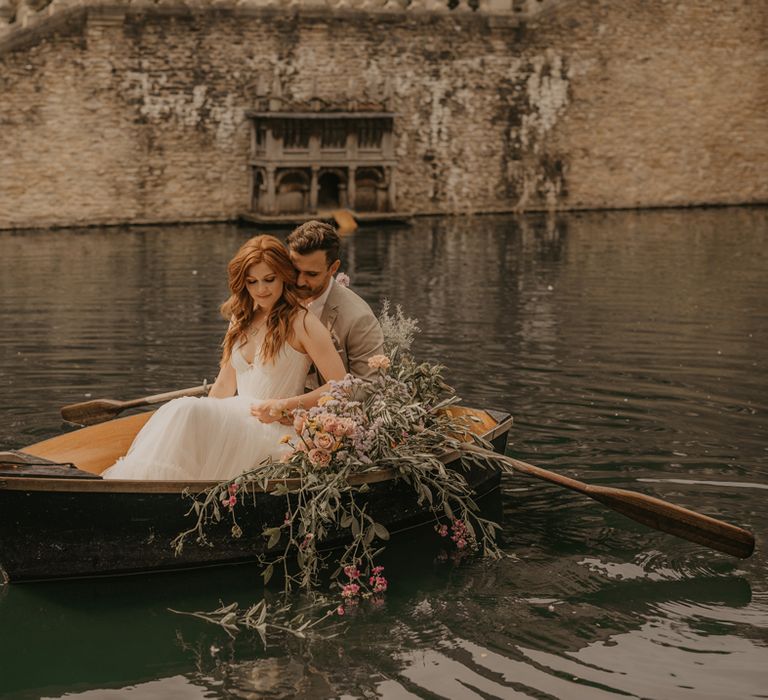 Bride and groom rowing a boat at The Lost Orangery, Euridge Manor