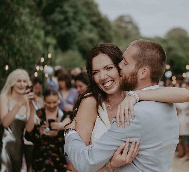 Groom kisses his new wife on the cheek