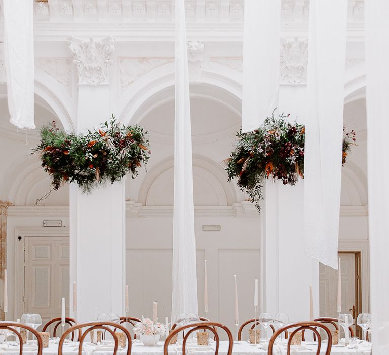 Historic Bylaugh Hall wedding with hanging drapes and pillars decorated in flowers 